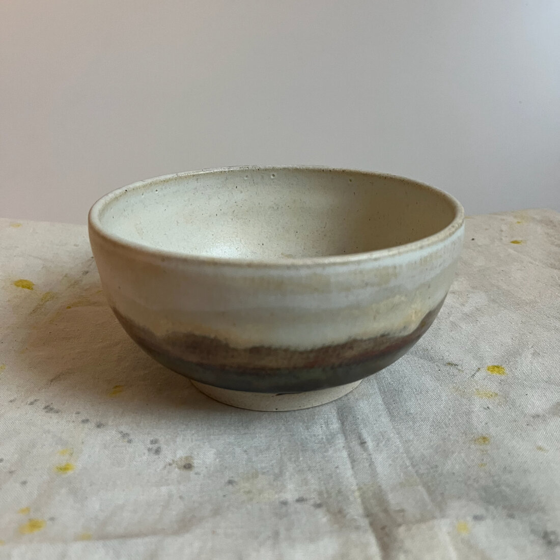 Handmade Landscape bowl, cream glaze with a warm banded edge, one of a pair
